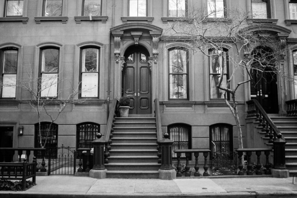 Brownstone building facade with black double doors and stoop staircase in Bedford-Stuyvesant, Brooklyn