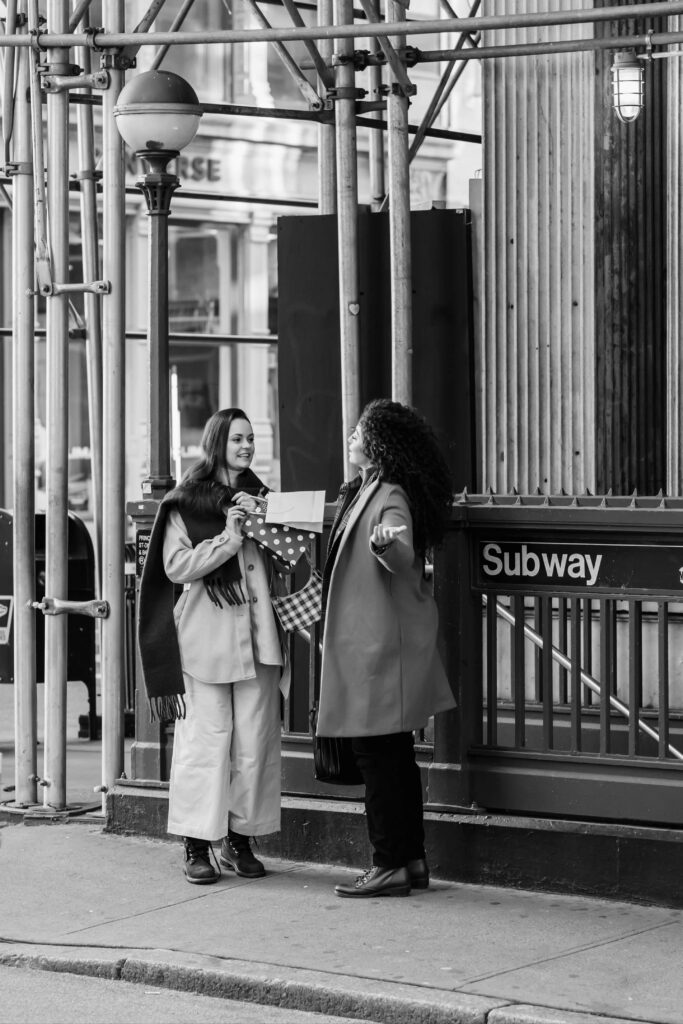 Two women chatting near a Brooklyn subway entrance